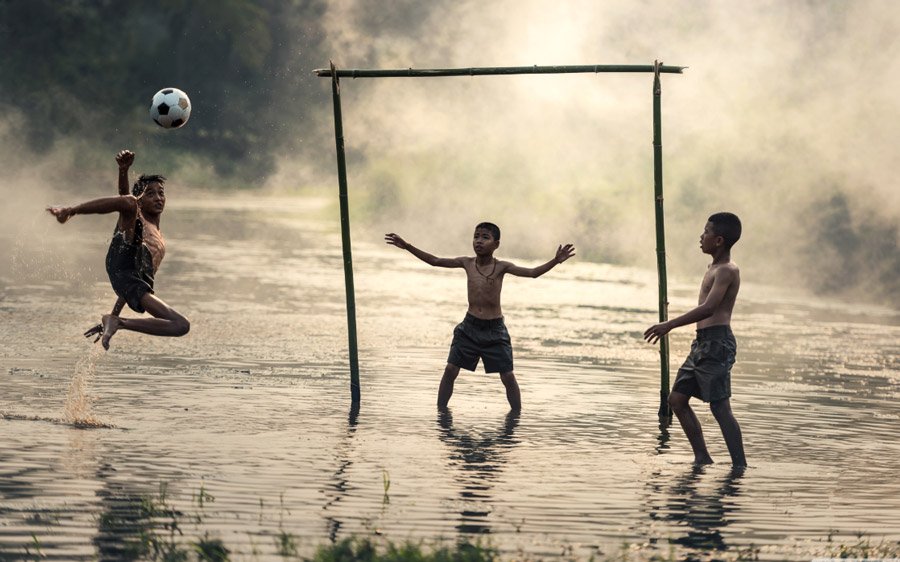 أطفال يلعبون كرة القدم بطريقة بدائية